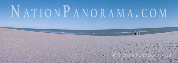 Two girls with mother walking at beach