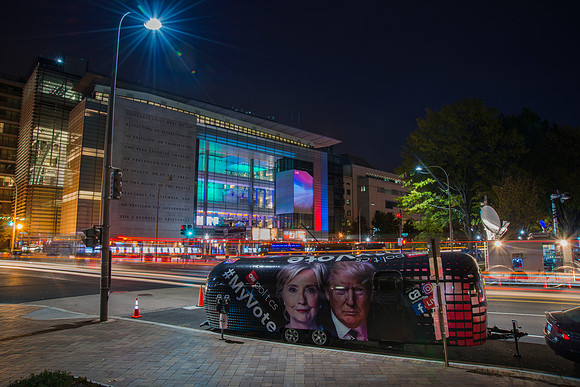 Night street view of CNN trailer with portraits of Presidential